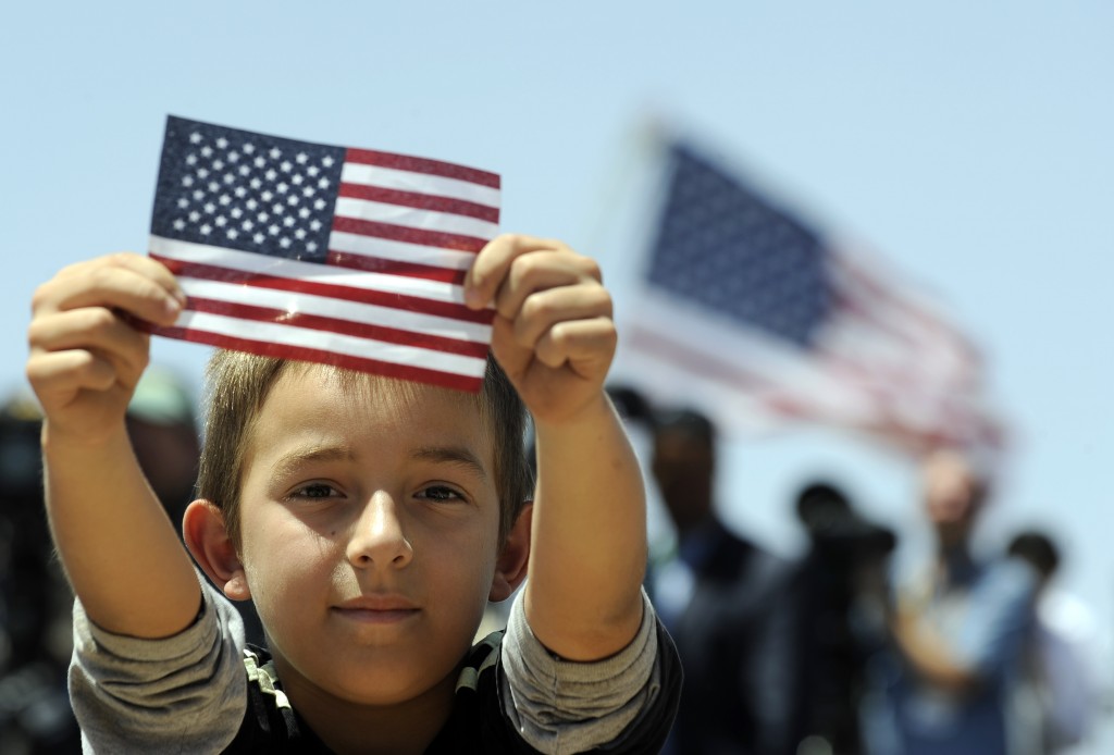 A boys shows a U.S. flag as President Barack Obama speaks about immigration at the Chamizal National Memorial in El Paso, Texas, in 2011. (Photo credit: Jewel Samad/AFP/Getty Images)