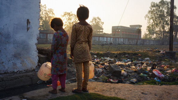 Two young girls stand outside the remains of the infamous Union Carbide plant in Bhopal, India. Half a million people were exposed during the plant’s 1984 gas leak and 25,000 have died to date as a result of their exposure. More than 120,000 people still suffer from ailments ranging from blindness to gynaecological disorders caused by the accident and subsequent pollution (Photo Credit: Giles Clarke/Getty Images).