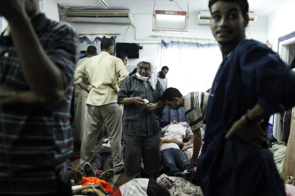 A supporter of deposed Egyptian President Mohammed Morsi stands among the bodies of dead pro-Morsi protesters on the floor of the Rabaa al-Adaweya Medical Centre in Cairo, Egypt (Photo Credit: Ed Giles/Getty Images).