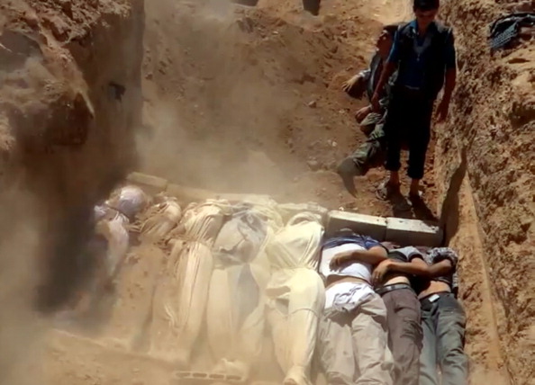Image from a civilian-uploaded YouTube video allegedly shows a mass grave of victims Syrian rebels claim were killed in a toxic gas attack by pro-government forces on the outskirts of Damascus. The allegation of chemical weapons being used in the heavily-populated areas came on the second day of a mission to Syria by U.N. inspectors. The claim could not be independently verified and was vehemently denied by the Syrian authorities, who said it was intended to hinder the mission of U.N. chemical weapons inspectors (Photo Credit: DSK/AFP/Getty Images).