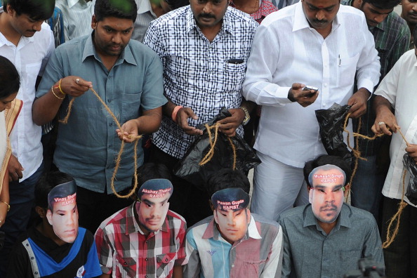Youths, wearing masks of the four convicted rapists, enact a mock execution following the sentencing in New Delhi of four men convicted of rape and murder (Photo Credit: Manjunath Kiran/AFP/Getty Images).