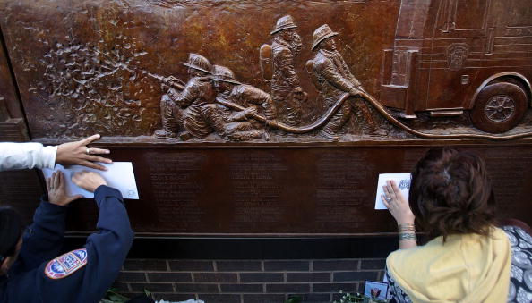 People make etchings of firefighter's names at a memorial dedicated to the 343 firefighters killed on 9/11. September 11, 2006 in New York City (Photo Credit: Mario Tama via Getty Images).