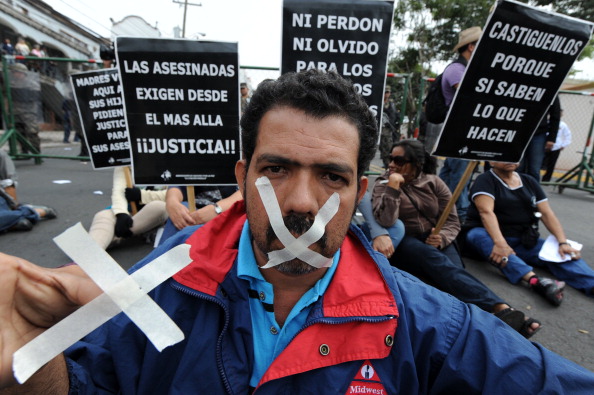 A journalist with his mouth taped takes part in a protest against the murder of colleagues in Tegucigalpa (Photo Credit: Orlando Sierra/AFP/Getty Images).