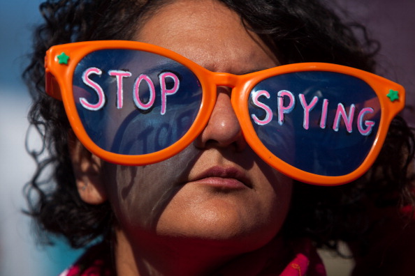 A woman listens to speakers during the Stop Watching Us Rally protesting surveillance by the U.S. National Security Agency in front of the U.S. Capitol building in Washington, D.C. (Photo Credit: Allison Shelley/Getty Images).