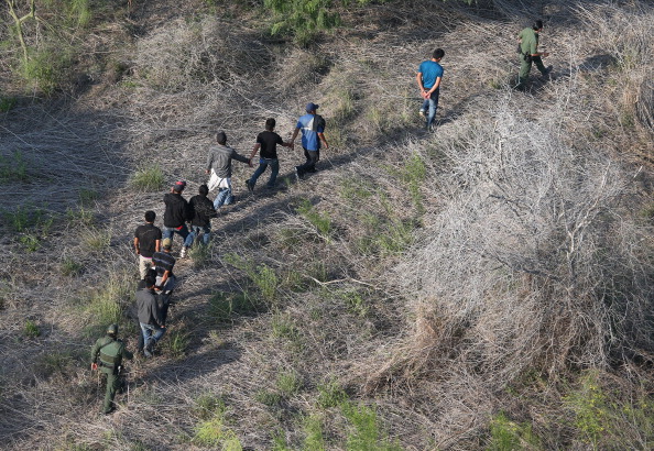 U.S. Border Patrol agents escort a group of undocumented immigrants into custody. (Photo Credit: John Moore/Getty Images)