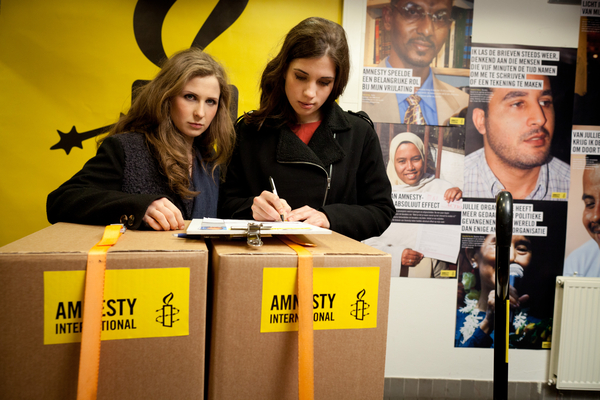 Nadya and Masha sign a petition calling for the Russian government to stop their crackdown on freedom of expression (Photo Credit: Jorn van Eck / Amnesty International).