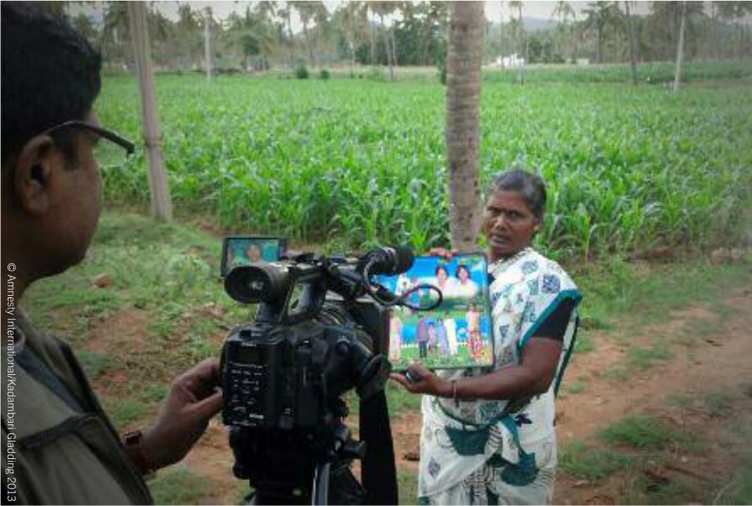 Jayamary, Simon's younger sister, holds a family photo from 30 years ago during the filming of a video by Amnesty International India (Photo Credit: Amnesty International).