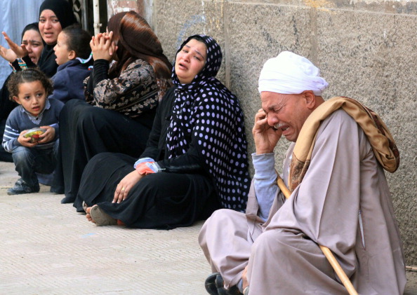 Egyptian relatives of supporters of ousted Islamist president Mohamed Morsi cry sitting outside the courthouse after the court ordered the execution of hundreds of Morsi supporters after only two hearings in March (Photo Credit: AFP/Getty Images).