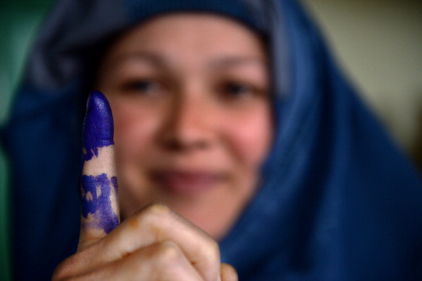 An Afghan voter shows her inked finger after she cast her ballot at a local polling station (Photo Credit: Shah Marai/AFP/Getty Images).