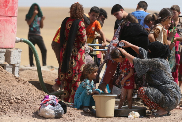Iraqi displaced people cool down at a temporary camp set up to shelter Iraqis fleeing violence in northern Iraq on June 18 (Photo Credit: Karim Sahib/AFP/Getty Images).