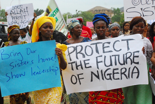 Women hold banners during a march of Nigeria women and mothers of the kidnapped girls of Chibok, calling for their freedom (Photo Credit: Philip Ojisua/AFP/Getty Images).