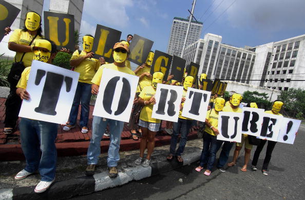 Activists in masks at an Amnesty International rally in Manila calling for an end to torture and human rights violations in the Philippines (Photo Credit: Jes Aznar/AFP/Getty Images).