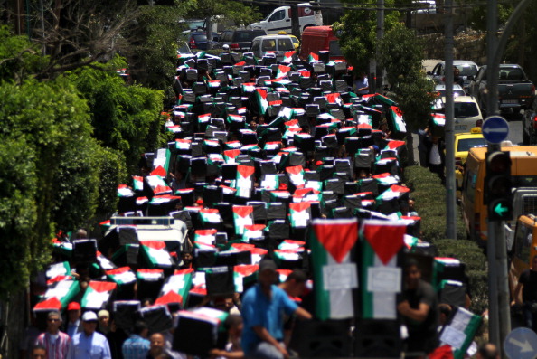 RAMALLAH, WEST BANK - JULY 23: People carry mock coffins covered with Palestinian flag are prepared for the killed people during the Israeli attacks to Gaza on July 23, 2014, in Ramallah, West Bank. . (Photo Credit: Shadi Hatem/Anadolu Agency/Getty Images)