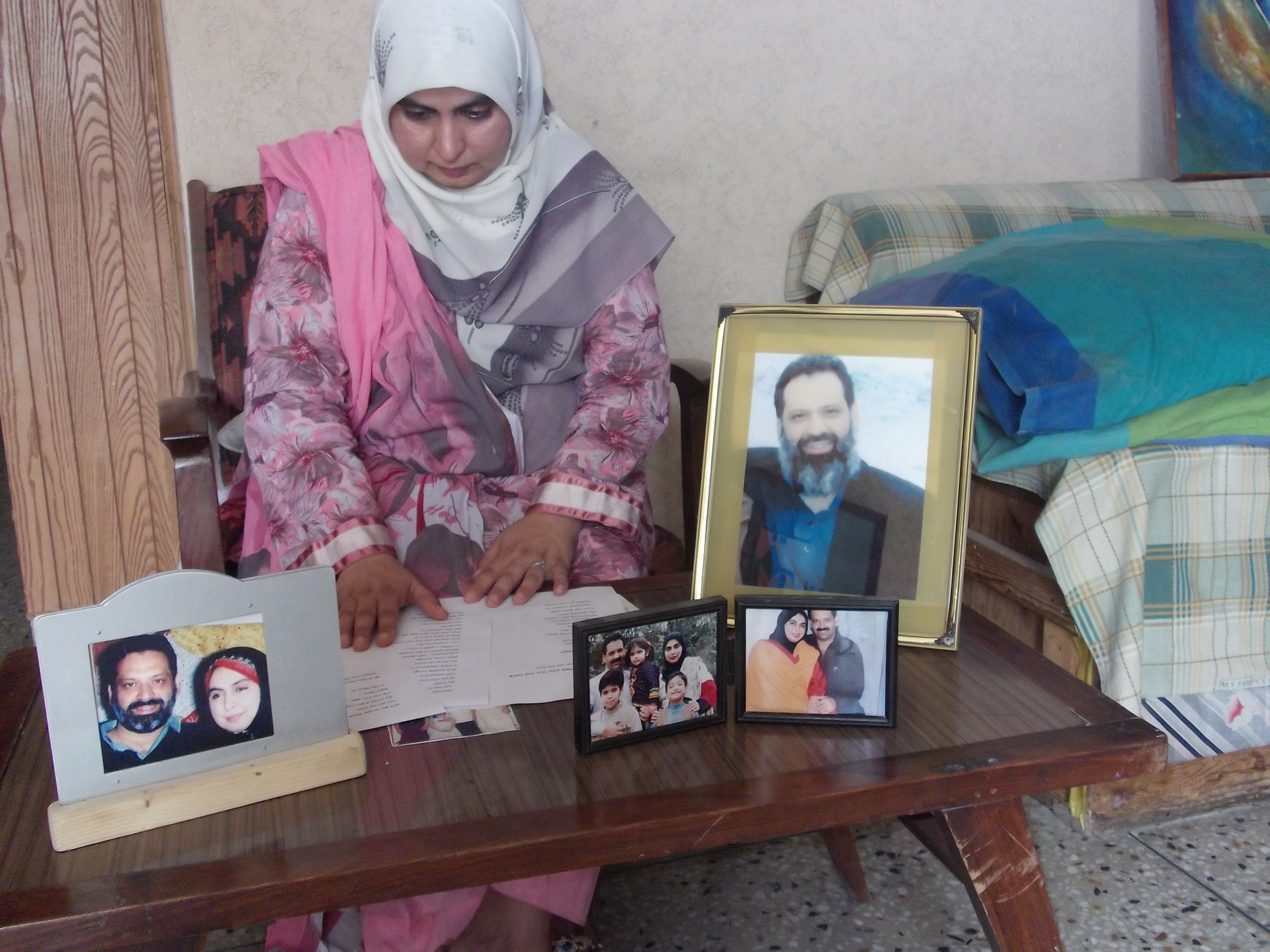 Amina Masood Janjua with photos of her husband, Masood Ahemd Janjua, a businessman from Rawalpindi.  Masood Janjua, along with his friend Faisal Faraz, an engineer from Lahore, were  forcibly disappeared? on 30 July 2005, at some point during a two-hour bus journey from Rawalpindi to Peshawar.  Their fate and whereabouts remain unknown.