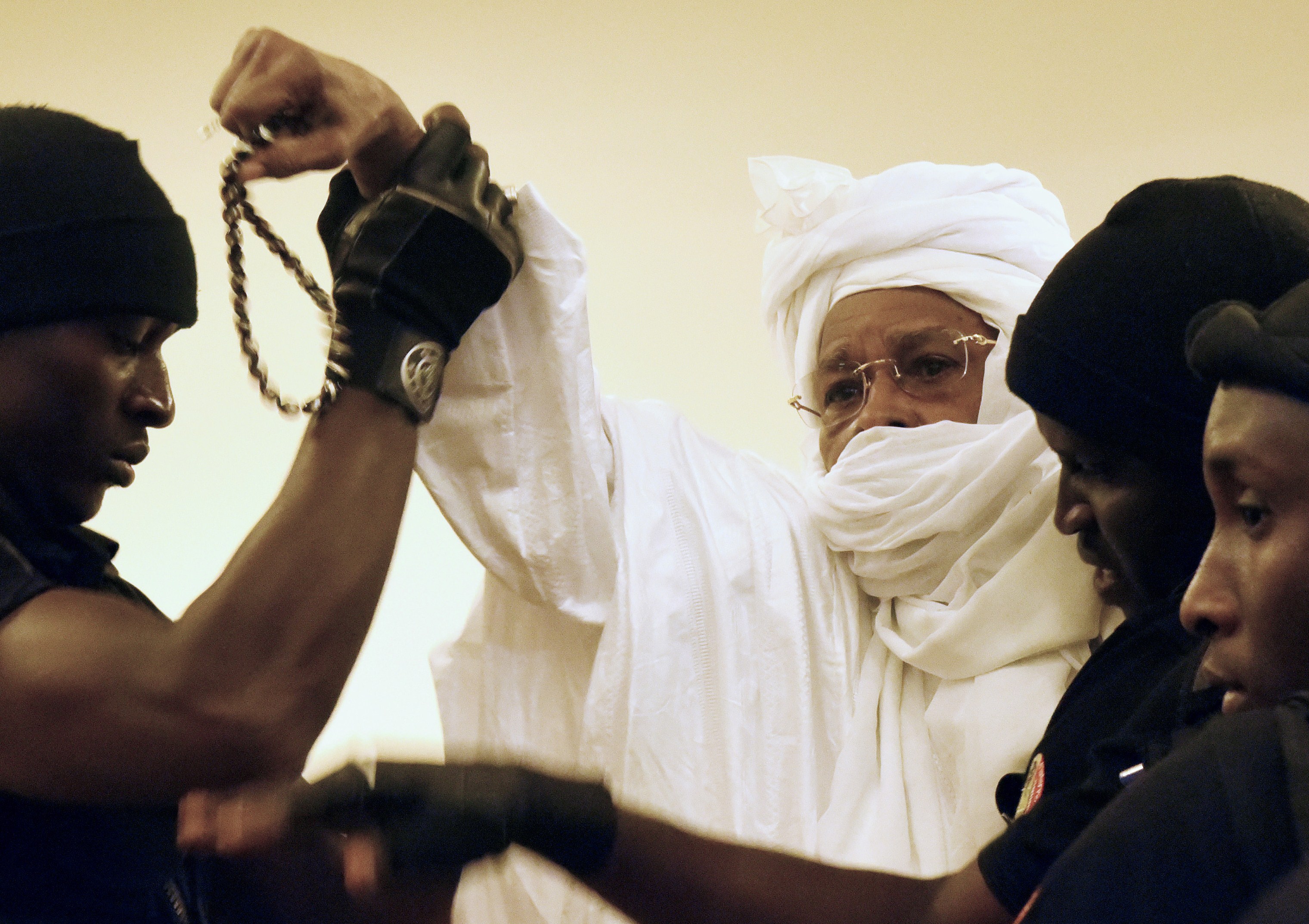 Former Chadian dictator Hissene Habre is escorted by prison guards into the courtroom for the first proceedings of his trial by the Extraordinary African Chambers in Dakar on July 20, 2015. (SEYLLOU/AFP/Getty Images)