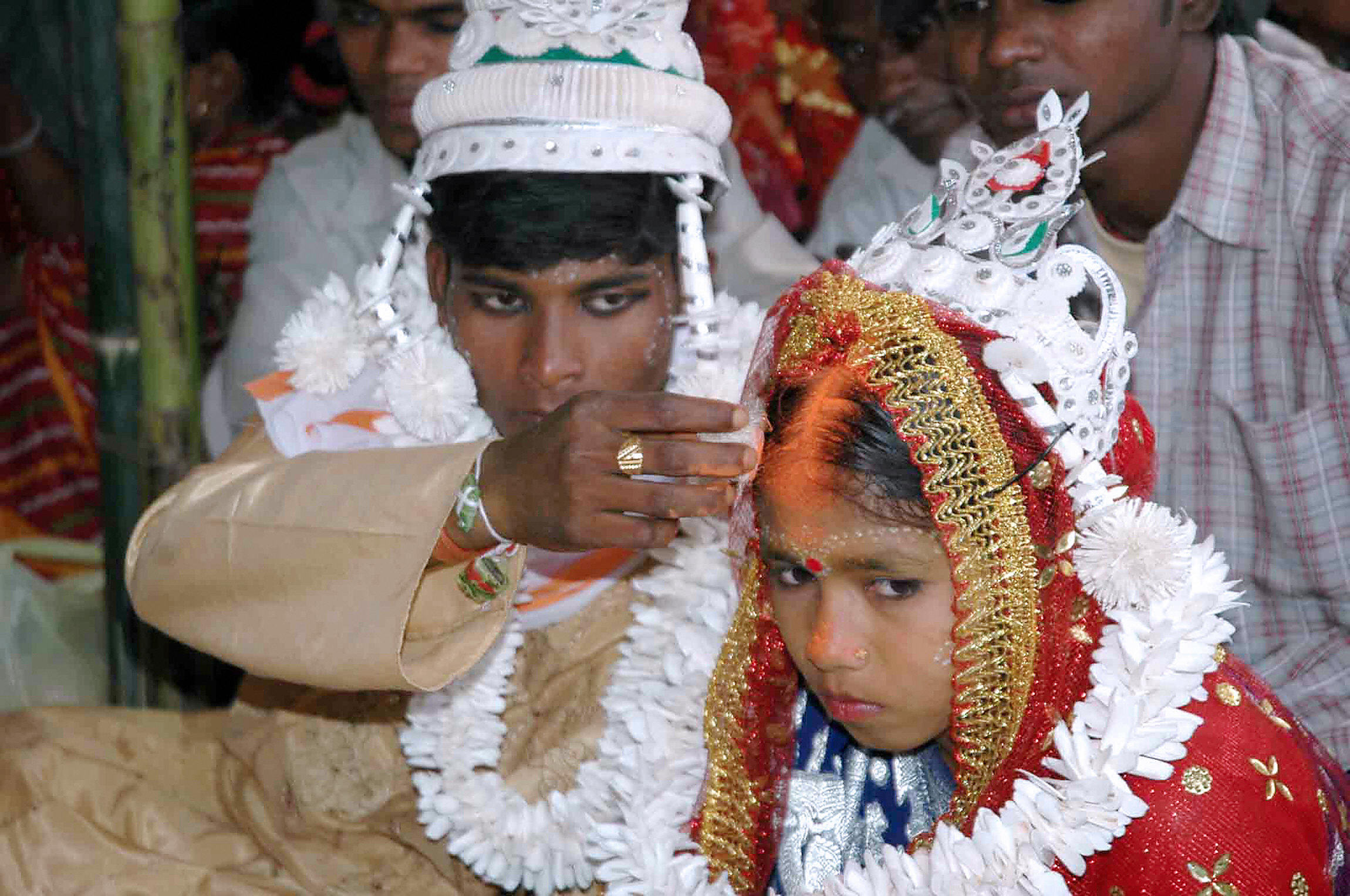 Indian groom puts vermilion on the forehead of his underage bride during a mass marriage in Malda, India 02 March 2006. (STRDEL/AFP/Getty Images)
