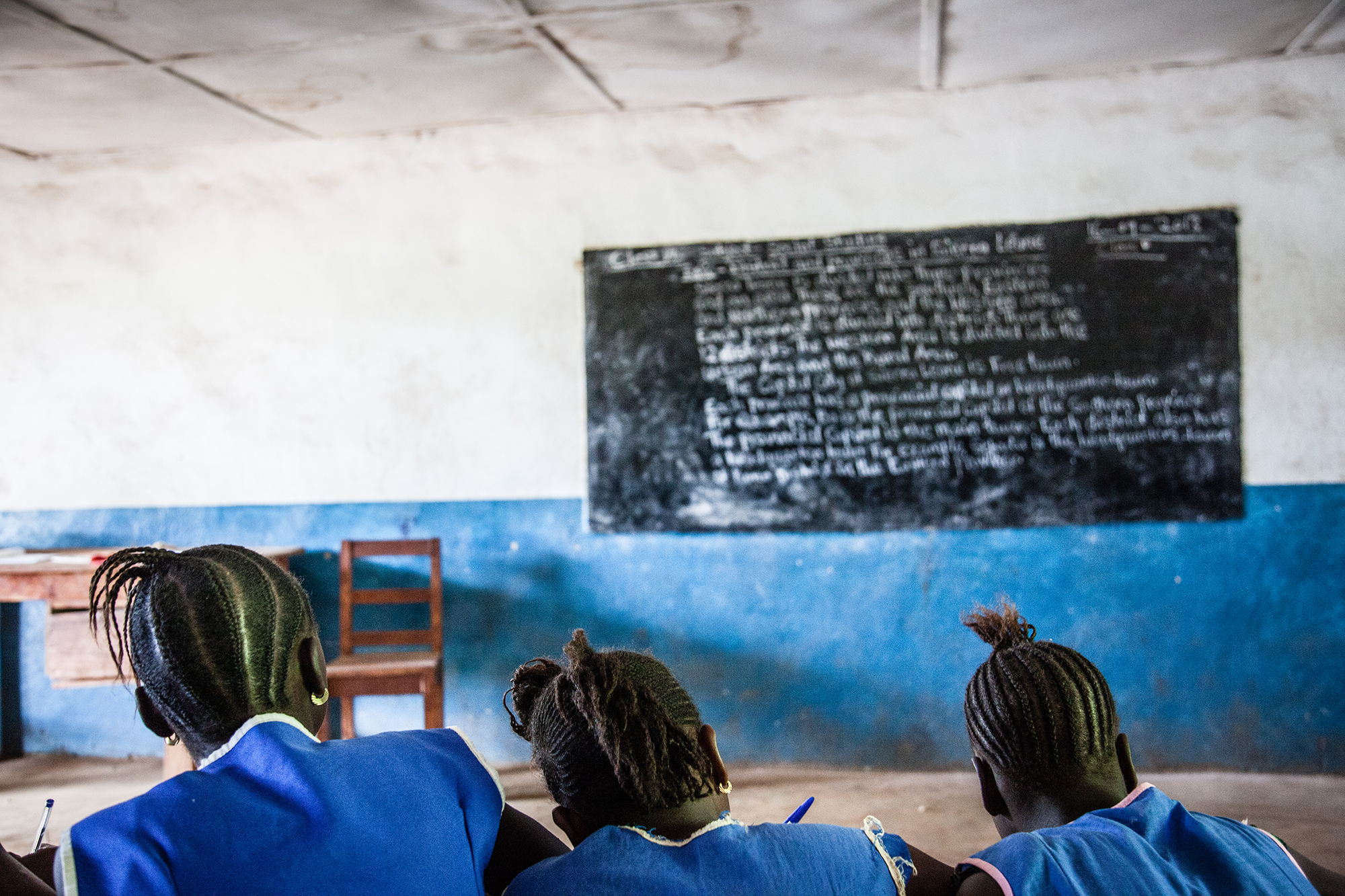 Anonymous school children, all girls, in front of a blackboard at an unidentified school somewhere in Sierra Leone.