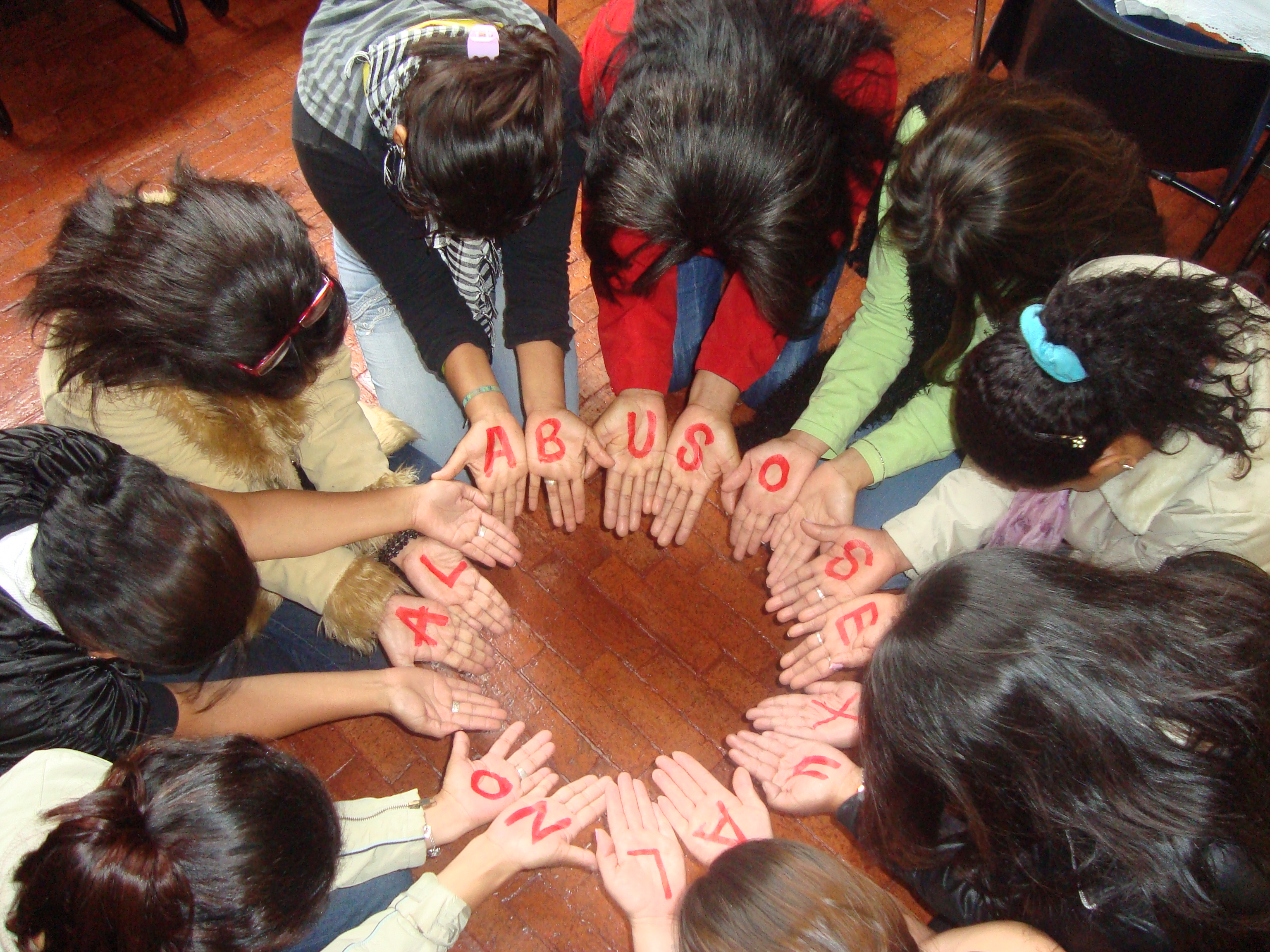 Members of a support group for survivors of sexual violence create a circle with their hands, Bogotá, Colombia, March 2011. The letters on the hands of the women in a circle form the words &quot;No al abuso sexual&quot; (No to sexual abuse). They are a group of women who have been victims of sexual violence in the armed conflict in Colombia who meet regularly.