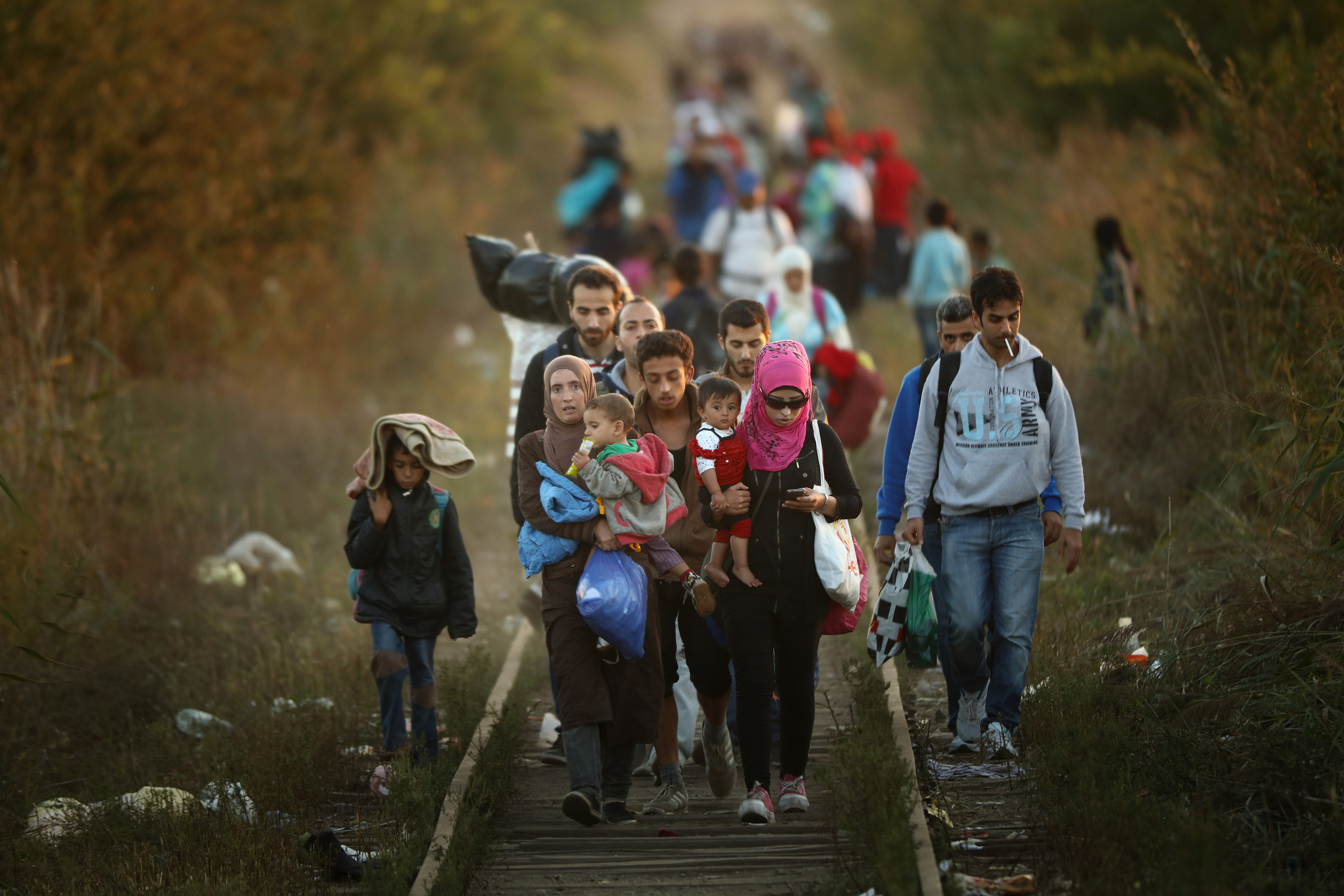 SUBOTICA, SERBIA - SEPTEMBER 09:  Migrants make their way through Serbia, near the town of Subotica, towards a break in the steel and razor fence erected on the  border by the Hungarian government on September 9, 2015 in Subotica, Serbia. Thousands of migrants have funnelled their way across country to the small gap in the steel fence unopposed by the authorities.  Since the beginning of 2015 the number of migrants using the so-called 'Balkans route' has exploded with migrants arriving in Greece from Turkey and then travelling on through Macedonia and Serbia before entering the EU via Hungary. The number of people leaving their homes in war torn countries such as Syria, marks the largest migration of people since World War II.  (Photo by Christopher Furlong/Getty Images)