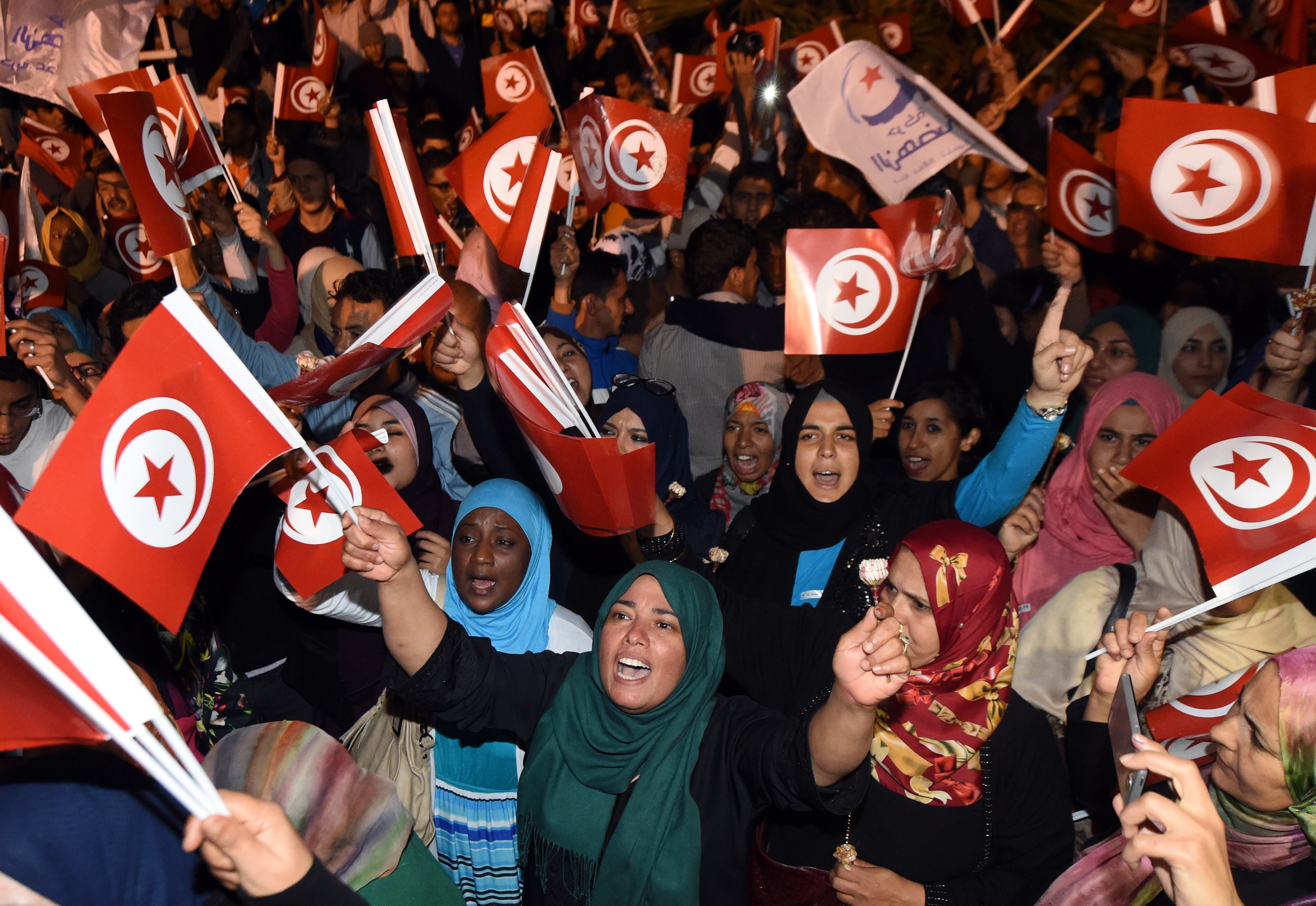 Tunisian Ennadha Party supporters wave flags as they wait for the party's leader to give a speech on October 27, 2014 in Tunis following the legislative election. The leader of Tunisia's Islamist Ennahda party congratulated his secular rival on October 26 for &quot;his party's win&quot; in a general election seen as critical for democracy in the cradle of the Arab Spring. The first parliamentary election since Tunisia's 2011 revolution pitted Ennahda against secular opponent Nidaa Tounes, with an array of leftist and Islamist groups also taking part. AFP PHOTO / FADEL SENNA        (Photo credit should read FADEL SENNA/AFP/Getty Images)