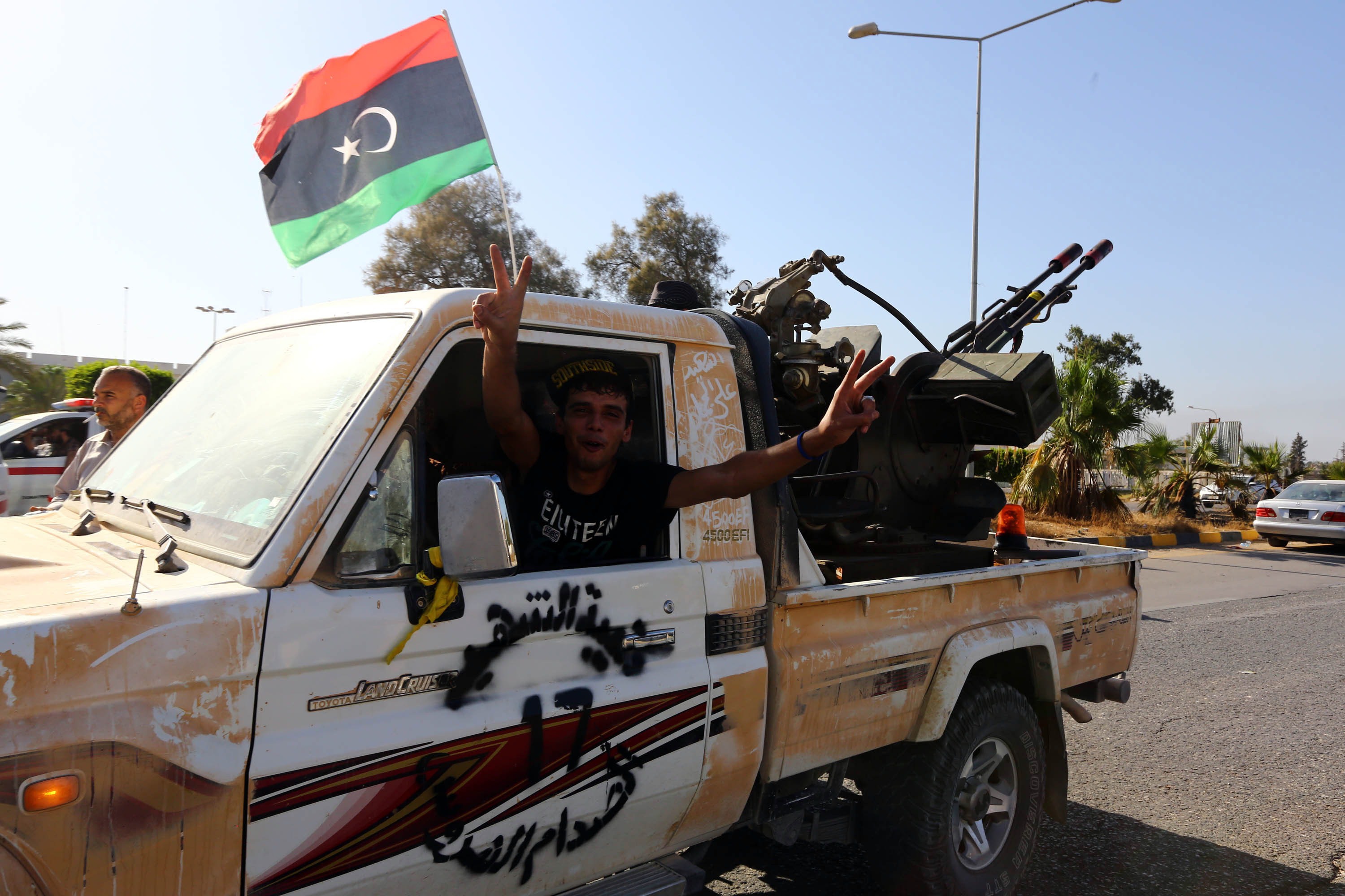 An Islamist fighter from the Fajr Libya (Libyan Dawn) coalition flashes the V sign for victory at the entrance of Tripoli international airport on August 24, 2014, after capturing it from Zintan force, allies of rogue general Khalifa Haftar, following many days of clashes.