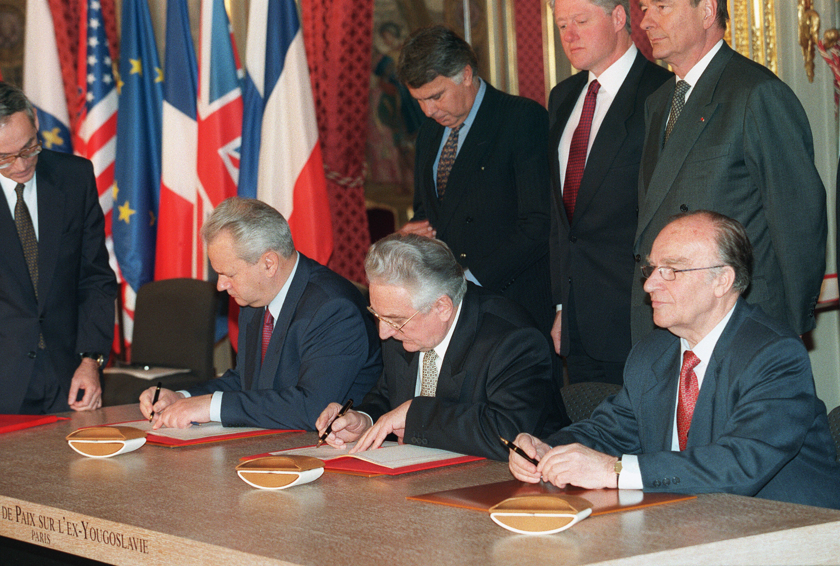 Paris, FRANCE: (FILES) This file picture taken 14 December 2005 at the Elysee Palace in Paris shows (1st Row L to R) Serbian president Slobodan Milosevic, Bosnian President Alija Izetbegovic (C) and Croatian President Franjo Tudjman signing the Dayton peace accord on Bosnia, as (2d row L to R) Spanish Prime Minister Felipe Gonzalez, US President Bill Clinton and French President Jacques Chirac look on. 14 December 2005 will mark the 10th anniversary of the signing of the Dayton peace agreement which ended more than three years of bloody inter-ethnic war and divided the country into a shaky system of separate but equal entities. AFP PHOTO/FILES/MICHEL GAGNE (Photo credit should read MICHEL GANGNE/AFP/Getty Images)