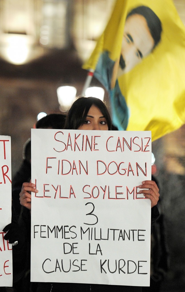 A woman of Kurdish origin holds a sign reading "Sakine Cansiz, Fidan Dogan, Leyla Soylemez - 3 women militants of the Kurdish cause" during a demonstration and commemoration in honor of the three Kurdish women activists killed yesterday in Paris, on January 10, 2013.