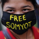 A Thai activist wears a face mask carrying a message reading 'Free Somyot' as she joins a protest outside the Criminal Court in Bangkok on January 25, 2013. (Photo credit: CHRISTOPHE ARCHAMBAULT/AFP/Getty Images)