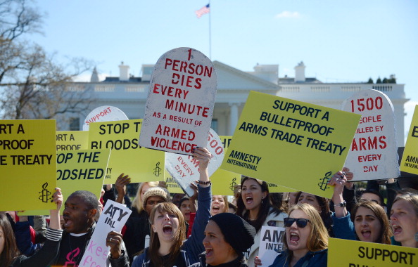 Demonstrators from Amnesty International chant outside the White House in Washington, D.C. as they call for strong support for a comprehensive global Arms Trade Treaty   (Photo Credit: Jim Watson/AFP/Getty Images).