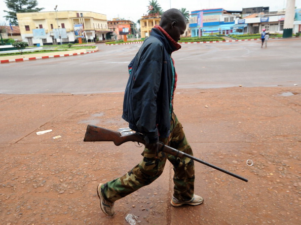 A man holds a rifle as he walks in a street of Bangui, Central African Republic (Photo Credit: Sia Kambou/AFP/Getty Images).